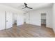 Bright bedroom with wood floors featuring ceiling fan with walk-in closet and ensuite bath at 10646 E Butherus Dr, Scottsdale, AZ 85255