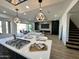 Modern kitchen island with cooktop and breakfast bar, open to the living room at 10646 E Butherus Dr, Scottsdale, AZ 85255