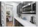 Kitchenette with elegant espresso cabinets, stainless steel microwave and white quartz countertops at 10646 E Butherus Dr, Scottsdale, AZ 85255