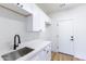 Well-lit laundry room offers white cabinets, stainless steel sink, and modern fixtures at 10646 E Butherus Dr, Scottsdale, AZ 85255