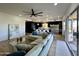 Living room with sectional sofa, large windows, and view of kitchen at 10646 E Butherus Dr, Scottsdale, AZ 85255