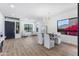 Stylish living and dining area with bright natural light, wood floors, and elegant chandelier at 10646 E Butherus Dr, Scottsdale, AZ 85255
