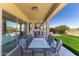Covered patio with table/chairs offers outdoor dining and entertaining near the grassy yard at 10646 E Butherus Dr, Scottsdale, AZ 85255