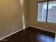 Simple bedroom with dark wood flooring and neutral walls at 44229 W Pioneer Rd, Maricopa, AZ 85139