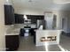 Modern kitchen with dark cabinets, stainless steel appliances, and an island at 44229 W Pioneer Rd, Maricopa, AZ 85139