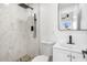 Modern bathroom with white tile, pebble floor, and black fixtures at 749 W Southgate Ave, Phoenix, AZ 85041