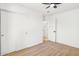 Well-lit bedroom with wood floors, ceiling fan, and door to hallway at 749 W Southgate Ave, Phoenix, AZ 85041