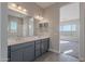 Double vanity bathroom with gray cabinets and a view of bedroom at 20257 W Catalina Dr, Buckeye, AZ 85396