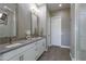 Bathroom with double sink vanity, modern lighting, and glass enclosed shower at 23461 N 76Th Pl, Scottsdale, AZ 85255