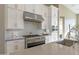 Modern kitchen featuring stainless steel appliances, white cabinets, and light gray backsplash tiles at 23461 N 76Th Pl, Scottsdale, AZ 85255