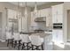 Stylish kitchen with a large island, pendant lighting, stainless steel appliances, and white cabinetry at 23461 N 76Th Pl, Scottsdale, AZ 85255