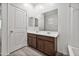 Bright bathroom featuring a double sink vanity with wood cabinets, large mirror, and tile flooring at 522 E Elm Ln, Avondale, AZ 85323