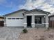 Charming single-story home features a two-car garage, stone accents, and low-maintenance desert landscaping at 40025 W Elm Dr, Maricopa, AZ 85138