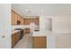 Well-equipped kitchen with light wood cabinetry, quartz countertops, and stainless steel appliances at 5214 W Rainwater Dr, Laveen, AZ 85339