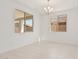 Well-lit living room featuring tile flooring, neutral paint, and contemporary chandelier at 5214 W Rainwater Dr, Laveen, AZ 85339