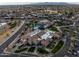 Aerial view of a community center with a pool, tennis courts, desert landscaping, and single-Gathering homes in the background at 16001 W Huron Dr, Sun City West, AZ 85375