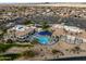 Aerial shot of a community pool with sun shades, a spa, and desert landscaping next to the community center at 16001 W Huron Dr, Sun City West, AZ 85375