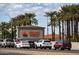 Sun City West entrance with palm trees, well-maintained landscaping, and a sign showcasing the community's name at 16001 W Huron Dr, Sun City West, AZ 85375