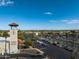 A parking lot view with palm trees, and a tower in the distance against a clear blue sky at 16001 W Huron Dr, Sun City West, AZ 85375