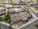 Aerial of many community tennis and pickleball courts landscaped with shade structures and a nearby parking lot and homes at 16001 W Huron Dr, Sun City West, AZ 85375