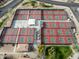 Aerial view of community tennis and pickleball courts, each fully fenced, with shade structures and landscaping at 16001 W Huron Dr, Sun City West, AZ 85375