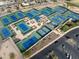 Aerial shot of well-maintained tennis courts with surrounding landscaping, parking, and neighborhood views at 16001 W Huron Dr, Sun City West, AZ 85375