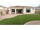 Well-maintained backyard with a covered patio, lush artificial turf, and privacy fencing at 21553 W Pierson St, Buckeye, AZ 85396