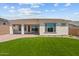 A well-maintained backyard showing the house with an expansive lawn and covered patio, ideal for entertaining at 21553 W Pierson St, Buckeye, AZ 85396