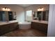 Spa-like bathroom featuring dual sinks, a soaking tub, and elegant tile work at 21553 W Pierson St, Buckeye, AZ 85396