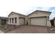 Charming single-story home featuring a three-car garage, desert landscaping, and a welcoming paver driveway at 21553 W Pierson St, Buckeye, AZ 85396