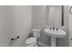 Well-lit powder room with modern fixtures, including a pedestal sink and sleek toilet at 21553 W Pierson St, Buckeye, AZ 85396