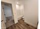 Clean bathroom with a bathtub, toilet, and wood-look flooring at 301 N Brower Rd, Maricopa, AZ 85139