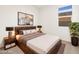 Bedroom with wood bed frame, neutral bedding, and abstract art at 30564 N Sydney Dr, San Tan Valley, AZ 85143