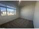 Bright, carpeted bedroom featuring a large window and neutral walls at 4301 E Bradford Ave, San Tan Valley, AZ 85143