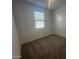 Carpeted bedroom with natural light, featuring a closet and a large window at 4301 E Bradford Ave, San Tan Valley, AZ 85143