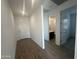 Hallway with wood-look tile floors, connecting to a bathroom and the front door at 4301 E Bradford Ave, San Tan Valley, AZ 85143