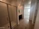 Glass shower, with white tiled walls, alongside modern bathroom vanity, and an adjacent bedroom at 4301 E Bradford Ave, San Tan Valley, AZ 85143