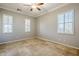 Neutral bedroom boasts tile floors, shuttered windows, and ceiling fan for comfort at 27587 N Makena Pl, Peoria, AZ 85383