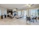 Open-concept living room with tile floors, fireplace, plantation shutters, and seamless flow to dining area at 27587 N Makena Pl, Peoria, AZ 85383