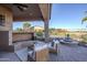 Inviting covered patio features an outdoor fireplace, seating area, and water fountain with view at 27587 N Makena Pl, Peoria, AZ 85383