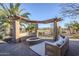 Outdoor patio features a cozy seating area, firepit, and landscaped surroundings at 27587 N Makena Pl, Peoria, AZ 85383