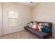 Cozy bedroom with a window and daybed accented by colorful pillows on the carpeted floor at 3468 E Desert Moon Trl, San Tan Valley, AZ 85143