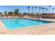 A sparkling community pool is surrounded by lounge chairs and palm trees for relaxation in the Arizona sun at 2336 N Salem St, Mesa, AZ 85215