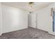 Bright, airy bedroom features neutral carpet and paint, ceiling fan, and a door leading to additional rooms at 542 S Higley Rd # 99, Mesa, AZ 85206