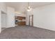 Spacious living room with neutral carpet, connecting to a kitchen with wood cabinets and a breakfast bar at 542 S Higley Rd # 99, Mesa, AZ 85206