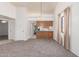 Open-concept living room with neutral carpet, a view of the kitchen, and a connecting hallway at 542 S Higley Rd # 99, Mesa, AZ 85206