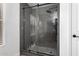 Modern bathroom shower with glass door, rainfall shower head, and pebble tile floor at 8913 E Oro Cir, Mesa, AZ 85212