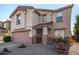 A charming two-story home with a terracotta tile roof and a two car garage at 8913 E Oro Cir, Mesa, AZ 85212