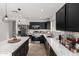 Modern kitchen with stainless steel appliances, waterfall island, and black cabinets at 8913 E Oro Cir, Mesa, AZ 85212