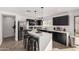 Bright kitchen with stainless steel appliances, a waterfall island, and black cabinetry at 8913 E Oro Cir, Mesa, AZ 85212